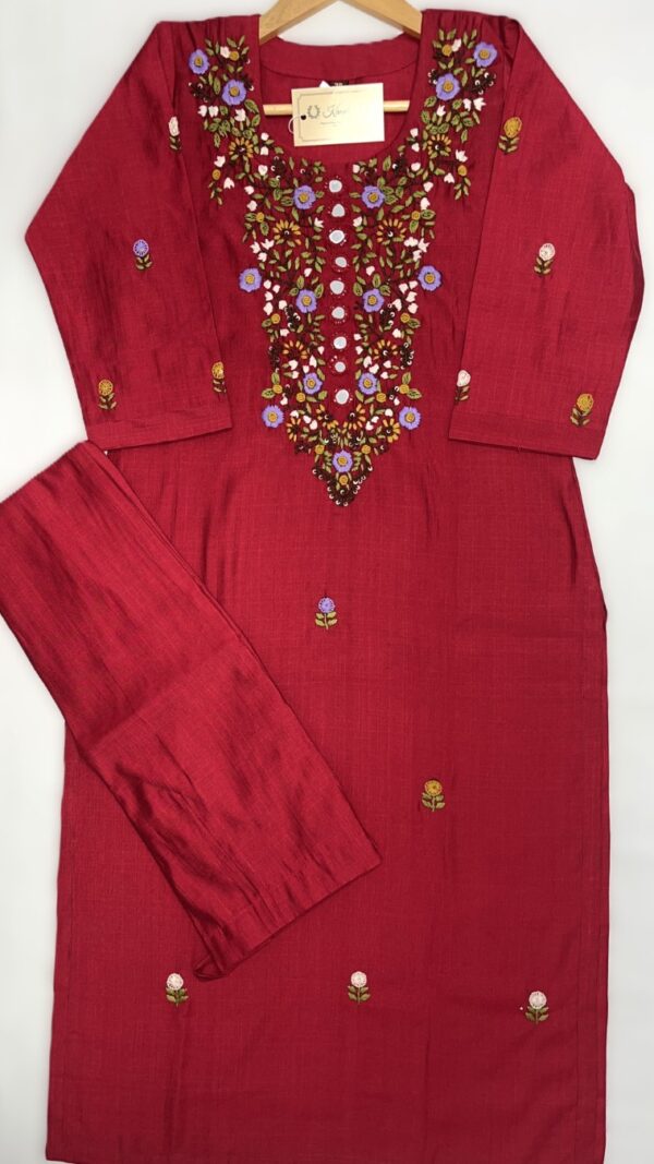 Red kurti with intricate multicolored floral embroidery around the neckline and scattered small floral motifs along the front and sleeves.